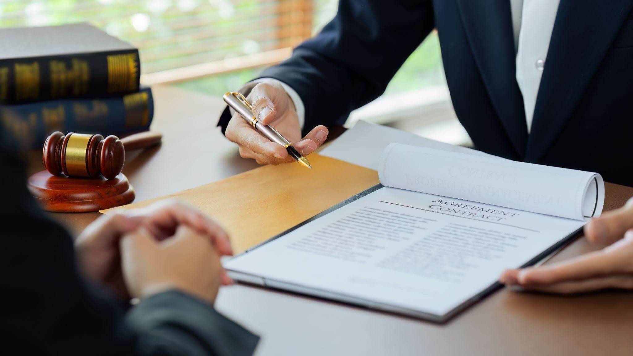 Person signing a legal document with a judge present
