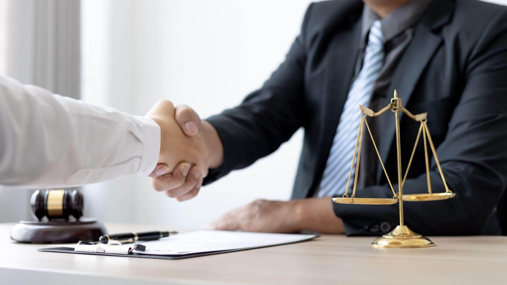 Two people shaking hands in front of scales